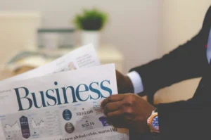 business-demo-newspaper Membaca media cetak sambil menunggu di lobi hotel.